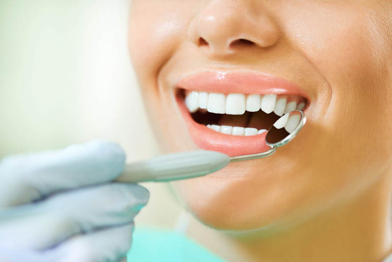 Woman teeth and a dentist mouth mirror