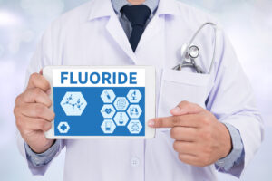 Dentist holding a sign that says fluoride