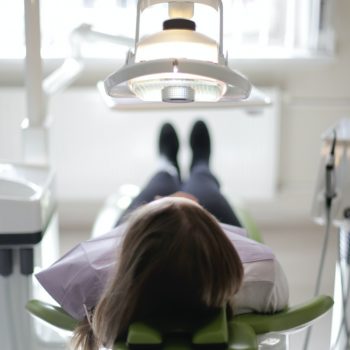 Woman laying in dentist chair for appointment.