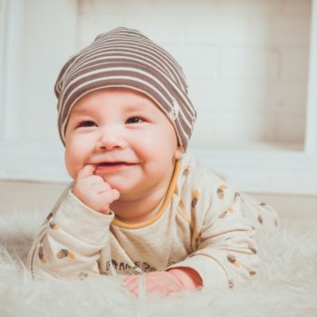 Baby smiling with a hat on.