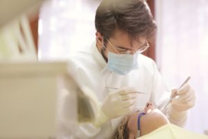 Dentist working on a patient's set of teeth and gums.
