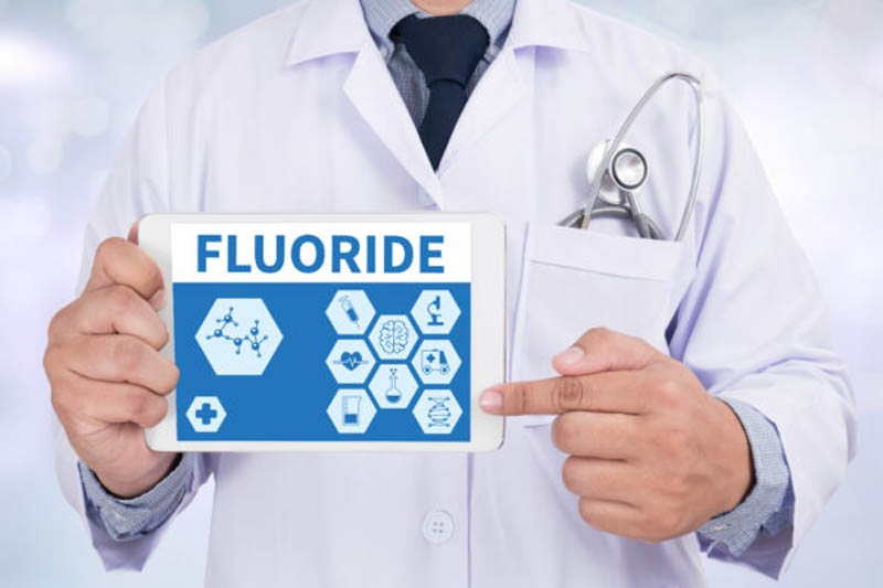 FLUORIDE Doctor holding digital tablet