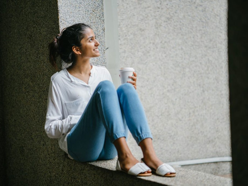 Asian women sitting with coffee in hand