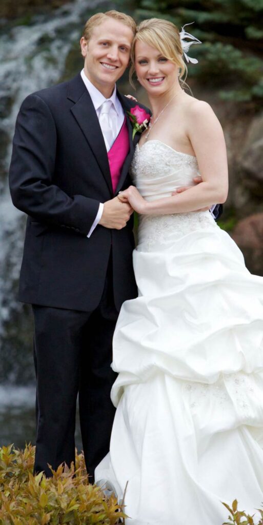 A man and woman pose happily in wedding attire