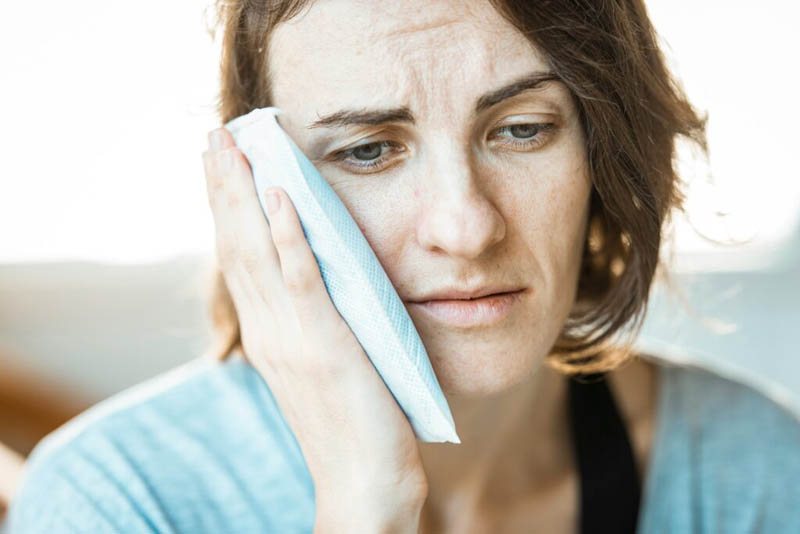 Woman suffering toothache at home